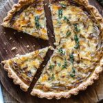 This delicious julia child alsatian onion tart is rich and savory, with golden caramelized onions, creamy Muenster cheese, and fresh thyme in a flaky tart crust. A perfect dish for brunch, lunch, or as a light dinner!